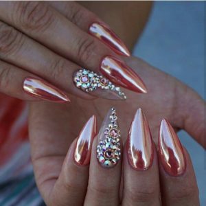 Rose gold chrome acrylic stiletto nails with rhinestone accent