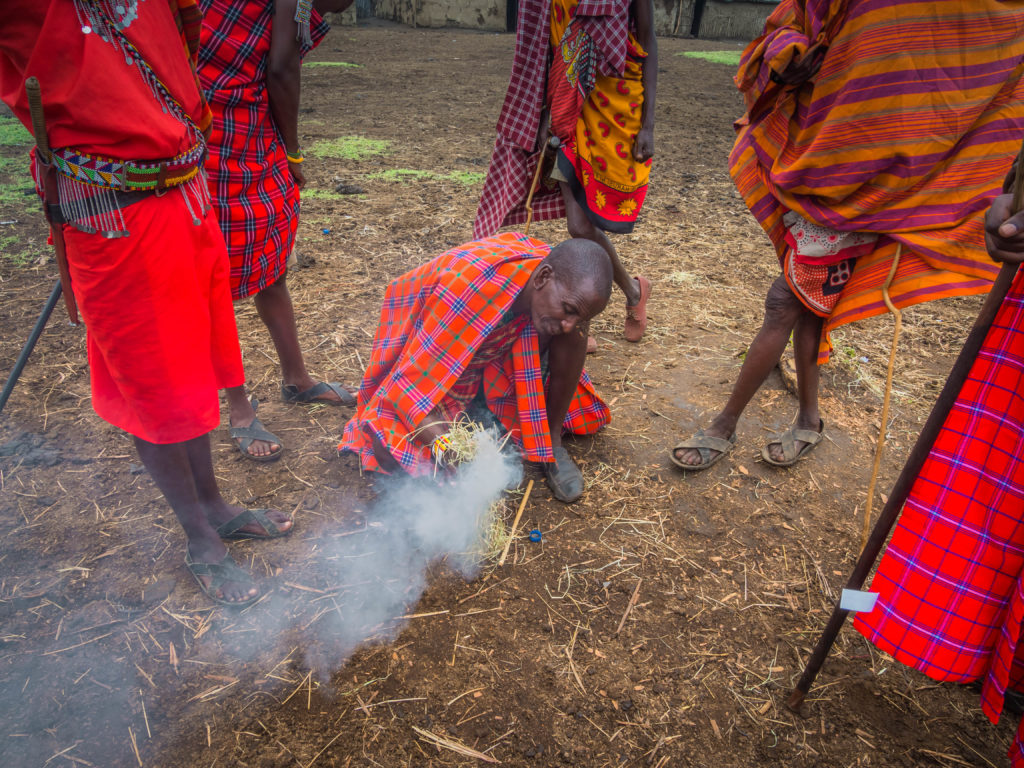 Travel - Visiting a Maasai Village - Kenyan Maasai Men demonstrate how to make a fire